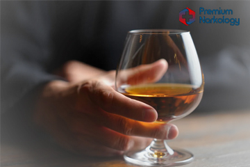 Мужчина держит бокал с алкоголем